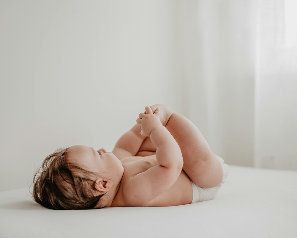 vauva makaa ja pitää kiinni varpaistaan neuvossa